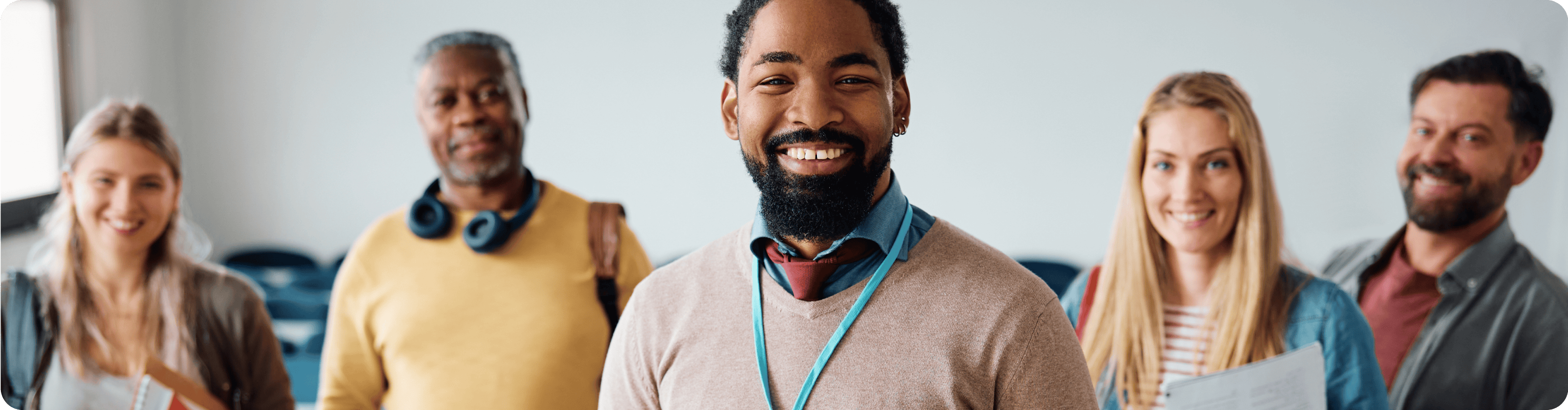 Two black and three white people are smiling.