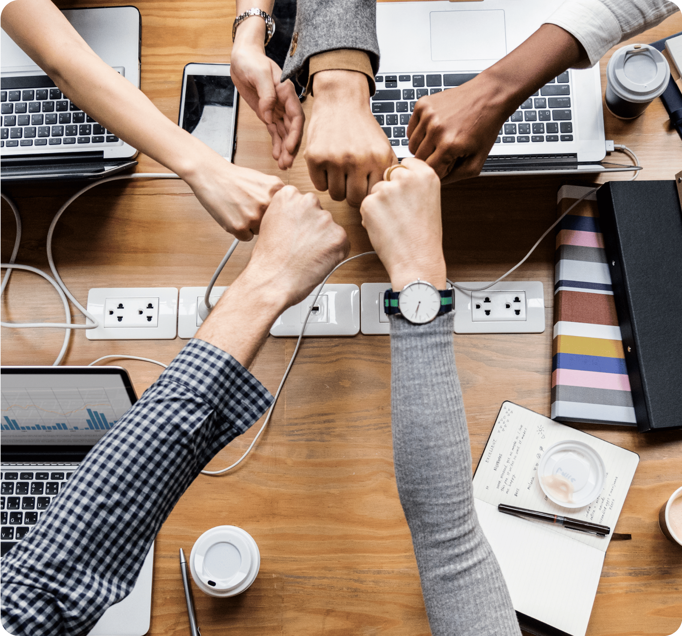 Five people are doing a group fist bump.