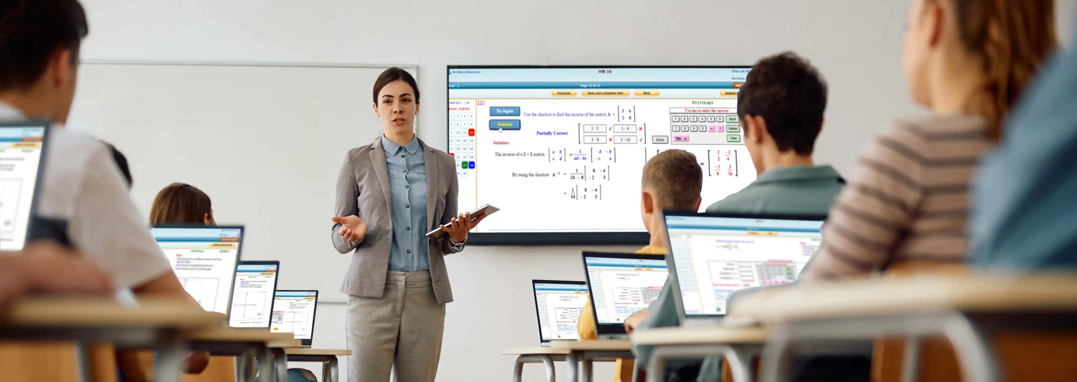 Teacher teaching with tablet in front of classroom